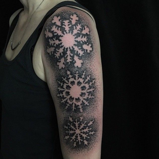 Tatuajes de copos de nieve en negativo por Tine DeFiore.